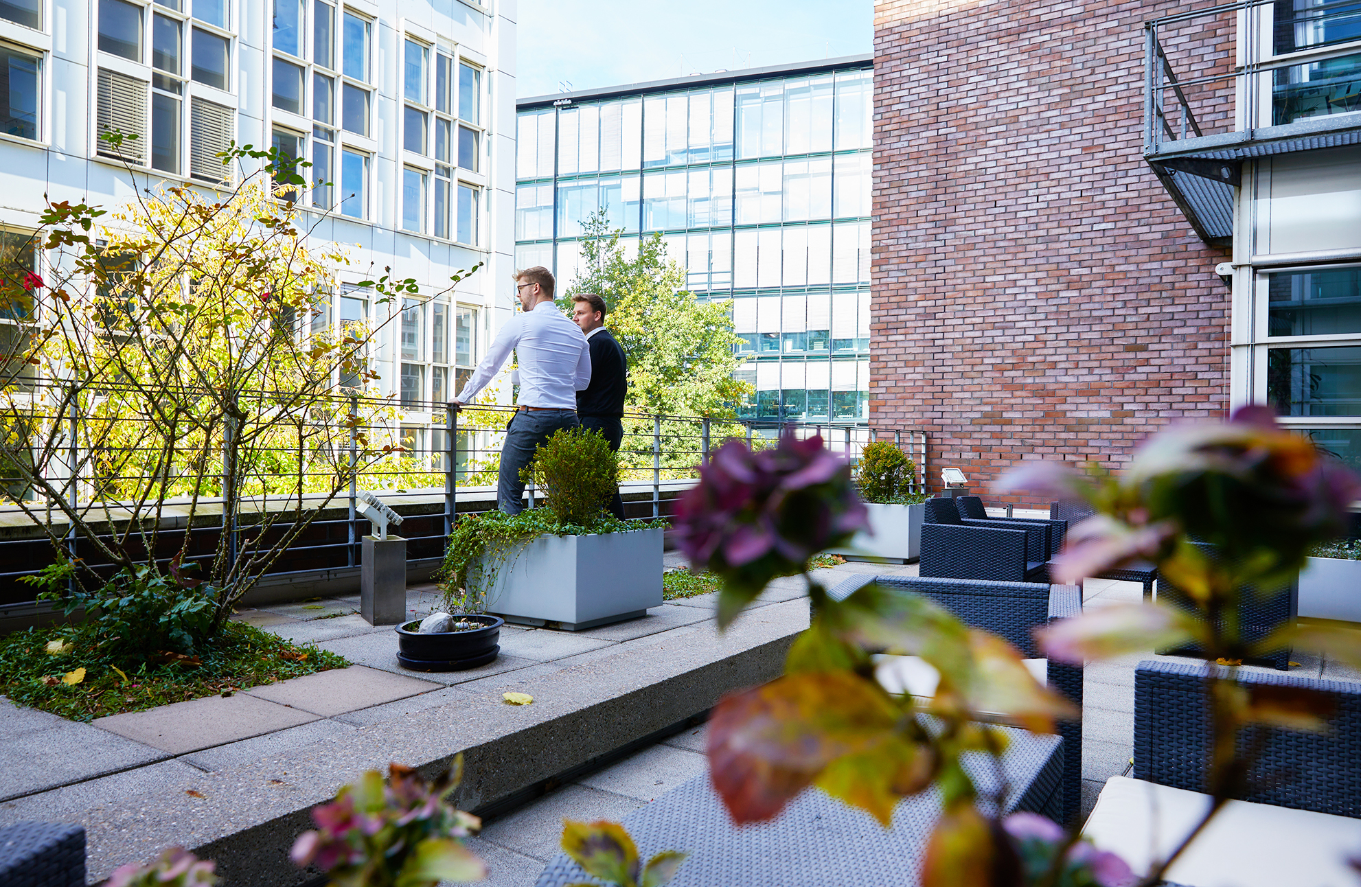 Zwei Mitarbeiter im Gespräch auf der Büroterrasse